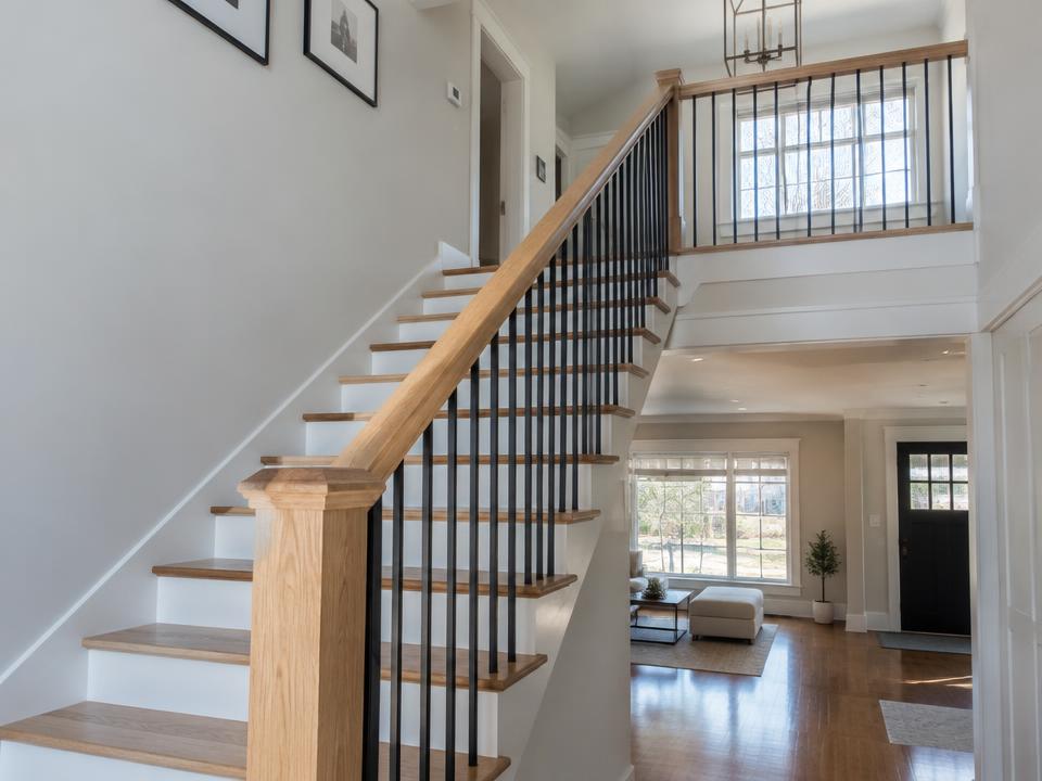 Interior staircase with black metal balusters and oak handrail